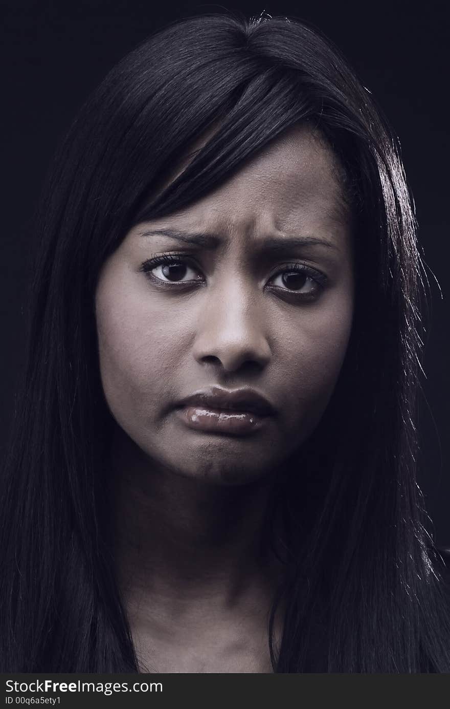 Close up of African American woman with a worried expression. She is frowning sadly. Close up of African American woman with a worried expression. She is frowning sadly.