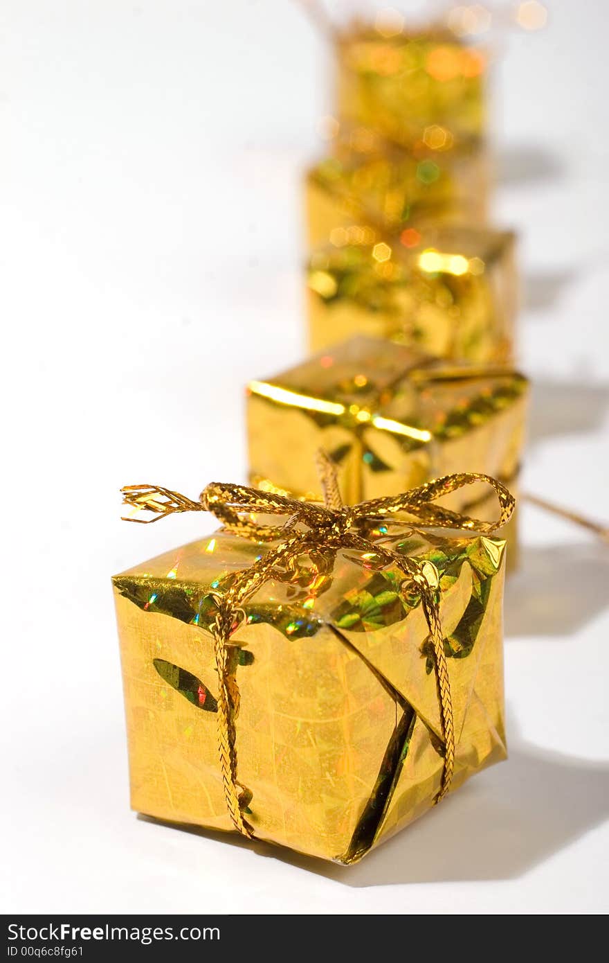 Golden wrapped gift boxes in a row. Golden wrapped gift boxes in a row