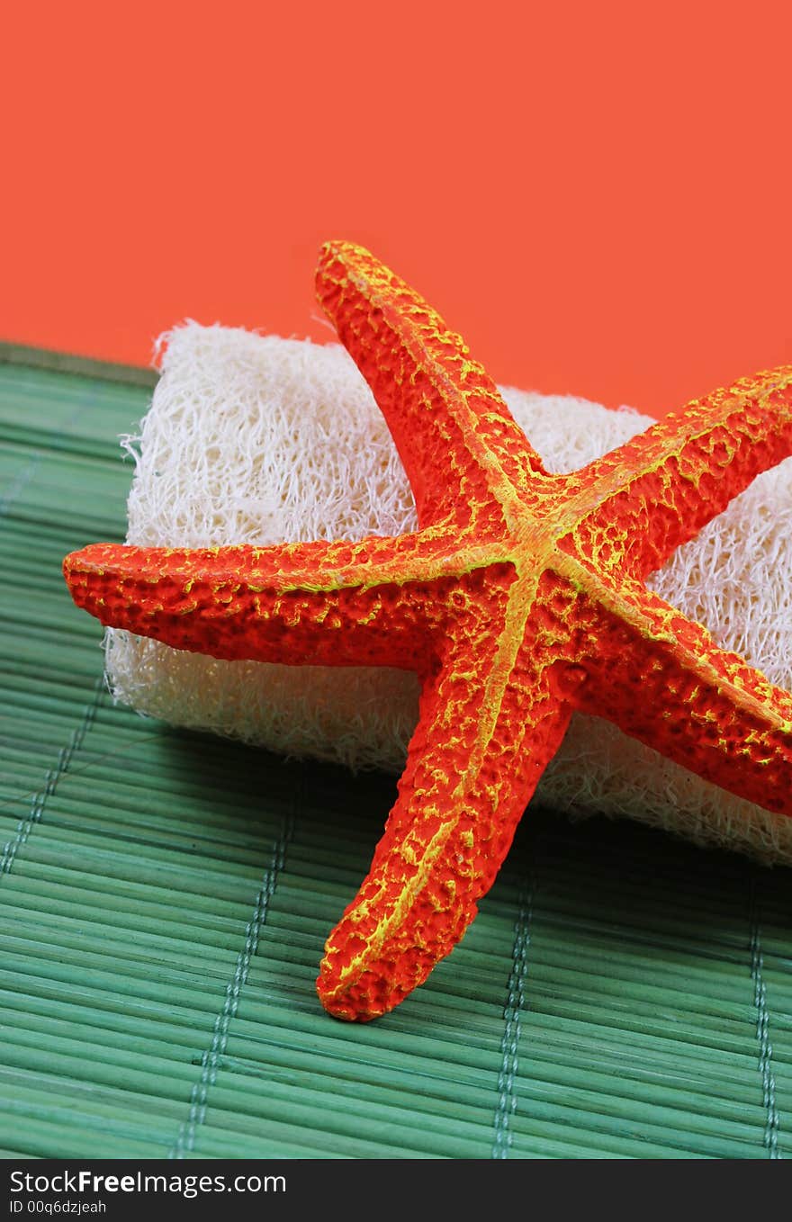 Spa and beauty products - orange starfish and loofah brush.