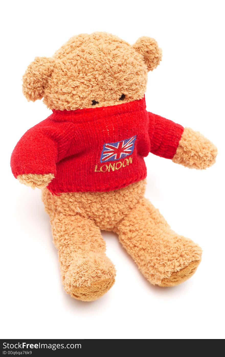 Brown teddy bear in red sweater on white