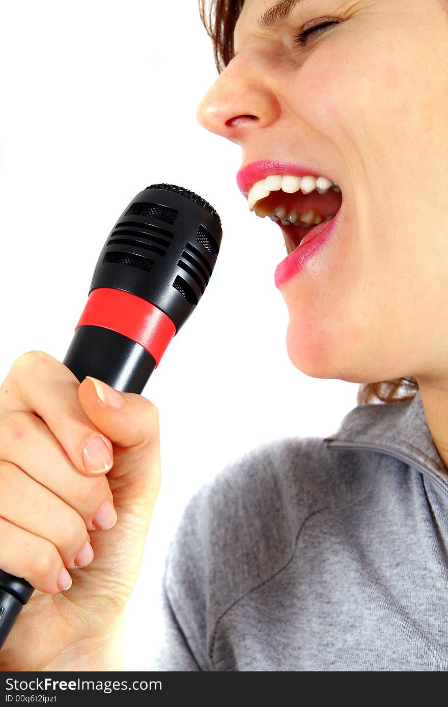 An isolated studio shot of young singer - using a microphone. An isolated studio shot of young singer - using a microphone.