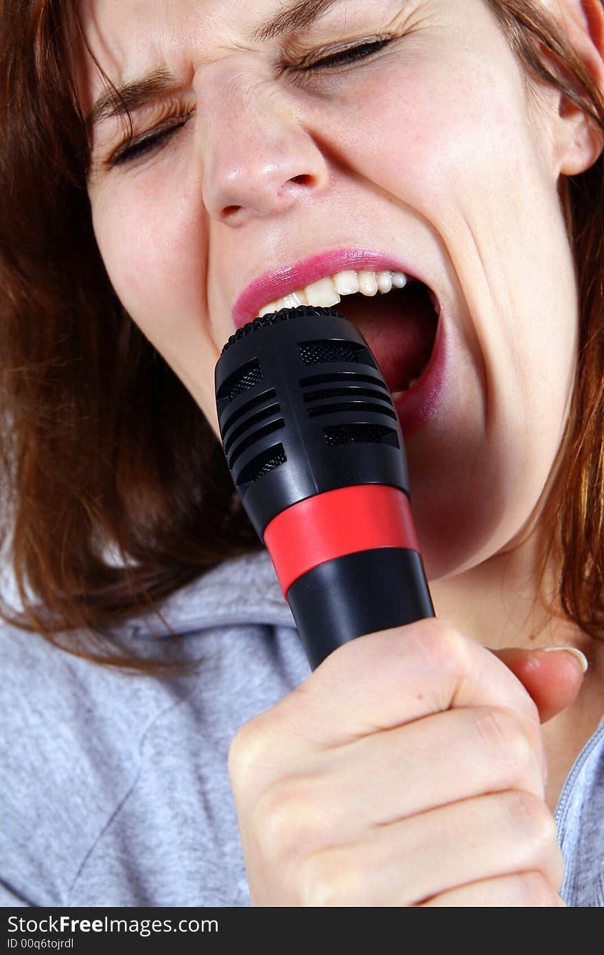 An isolated studio shot of young singer - using a microphone. An isolated studio shot of young singer - using a microphone.