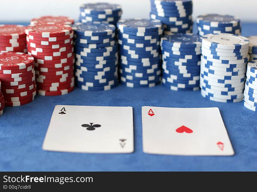 A hand of two aces in front of some poker chips