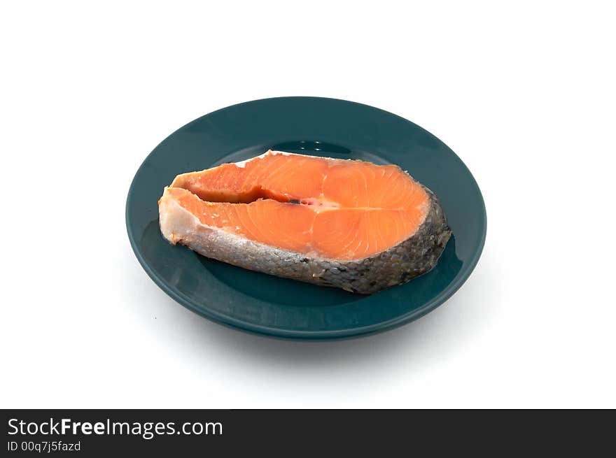 Fresh uncooked Pacific Coast Salmon on a plate of green color. 
It is not isolated, and it is photographed on a white background.