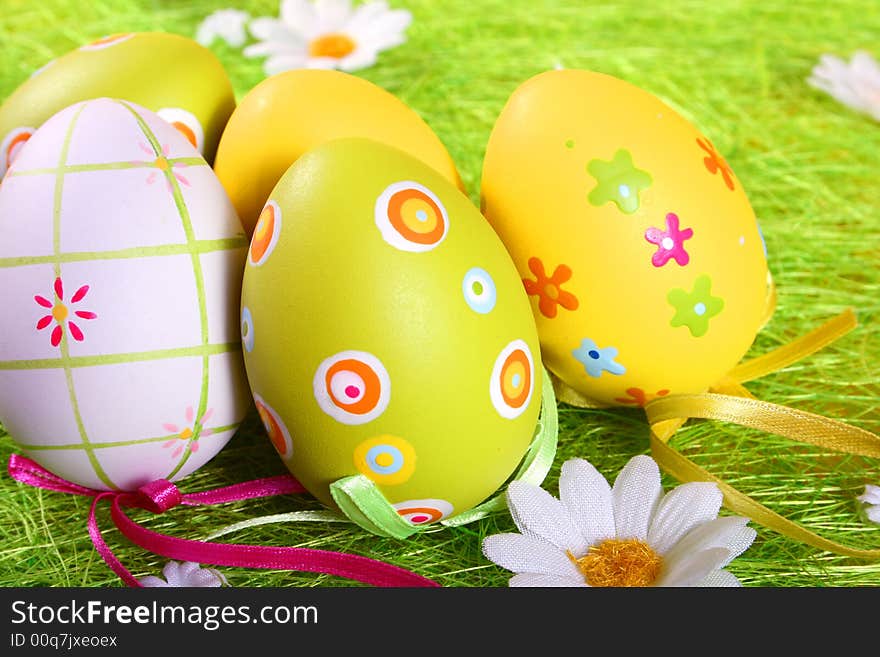 Pastel and colored Easter eggs on green