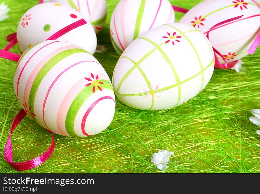 Pastel and colored Easter eggs on green