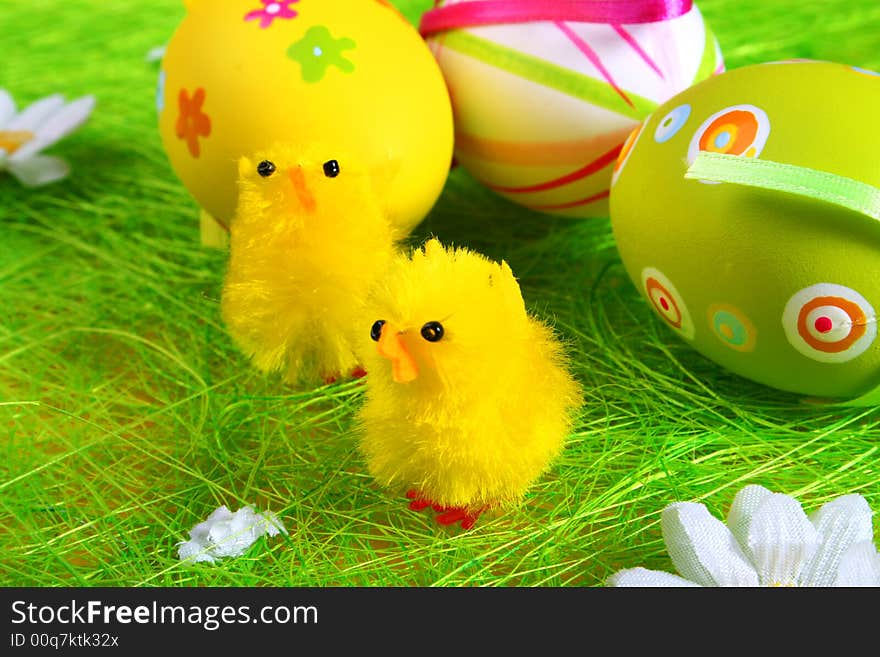 Pastel and colored Easter eggs on green