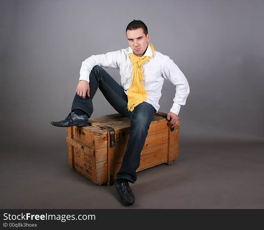 Modern young guy sitting on the wooden box