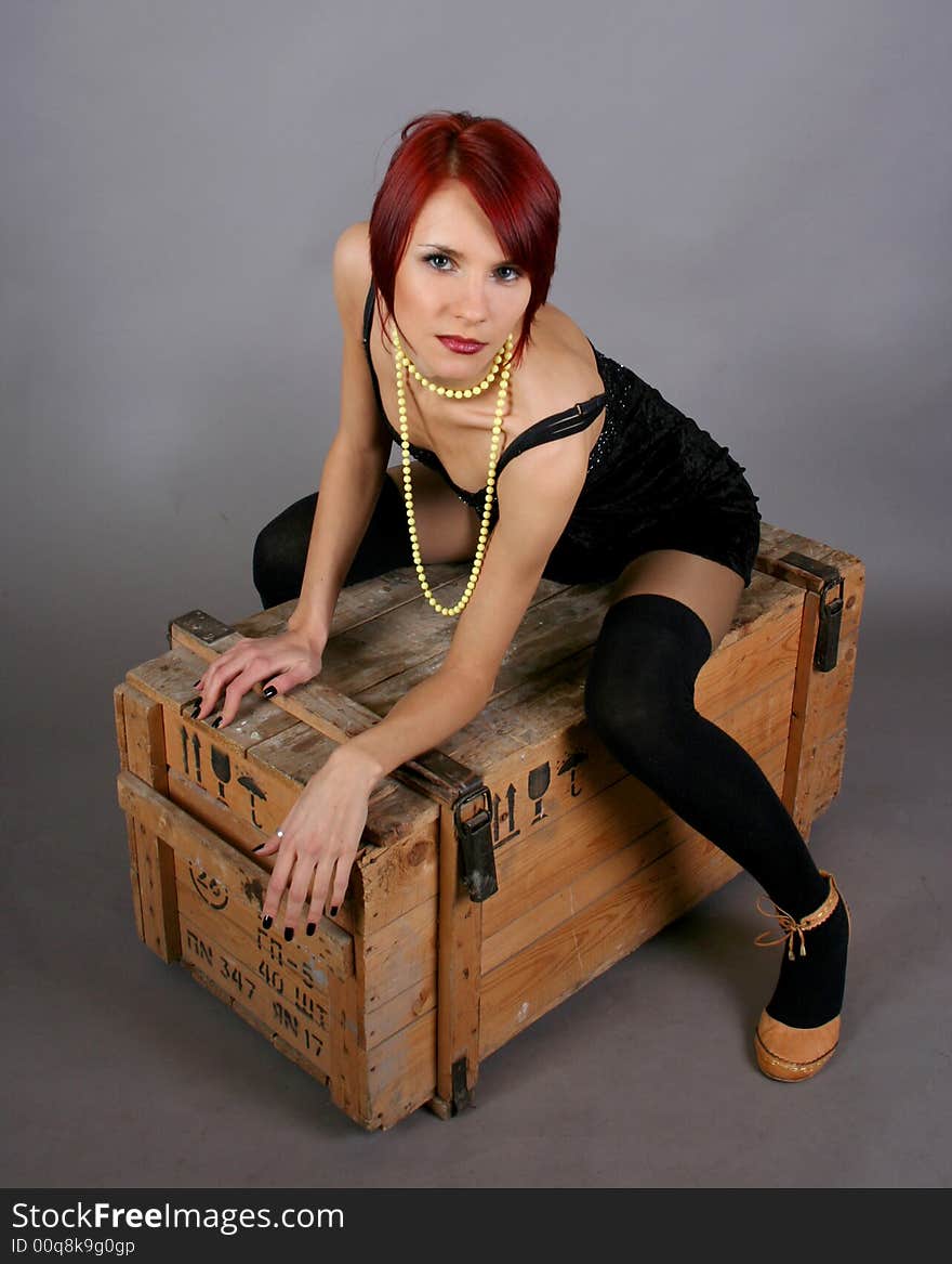 Sexy girl sitting on the wooden box