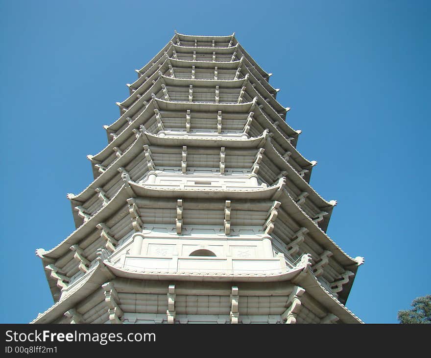 A white tower in the blue sky. A white tower in the blue sky