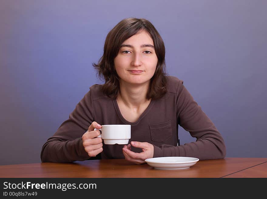 The beautiful girl with a coffee mug on a grey background. The beautiful girl with a coffee mug on a grey background