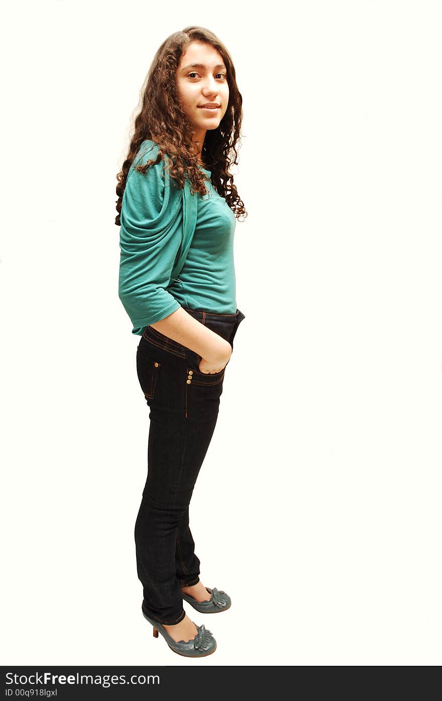 A young girl in jeans and turquoise sweater standing for white background. A young girl in jeans and turquoise sweater standing for white background.