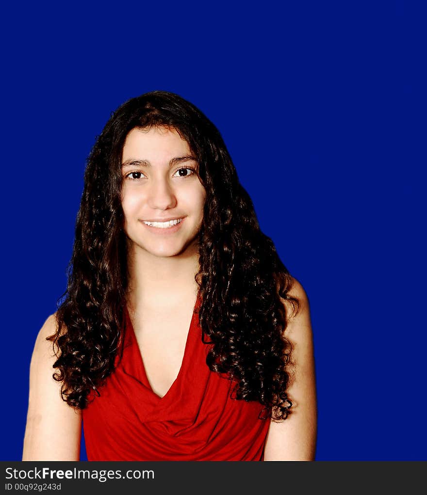 A young girl in red sweater standing for blue background. A young girl in red sweater standing for blue background.