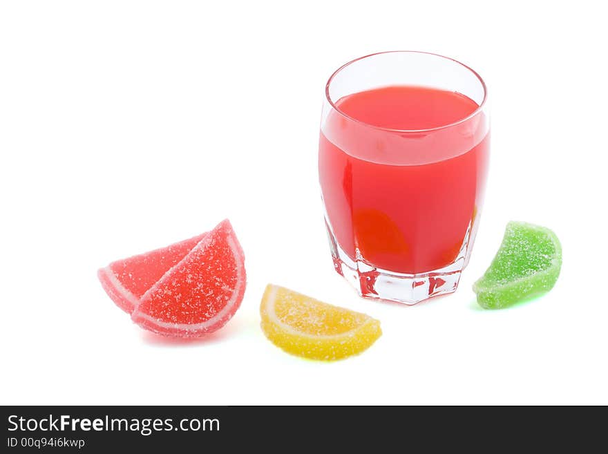 Glass of red juice and colorfull fruit jellies isolated. Glass of red juice and colorfull fruit jellies isolated