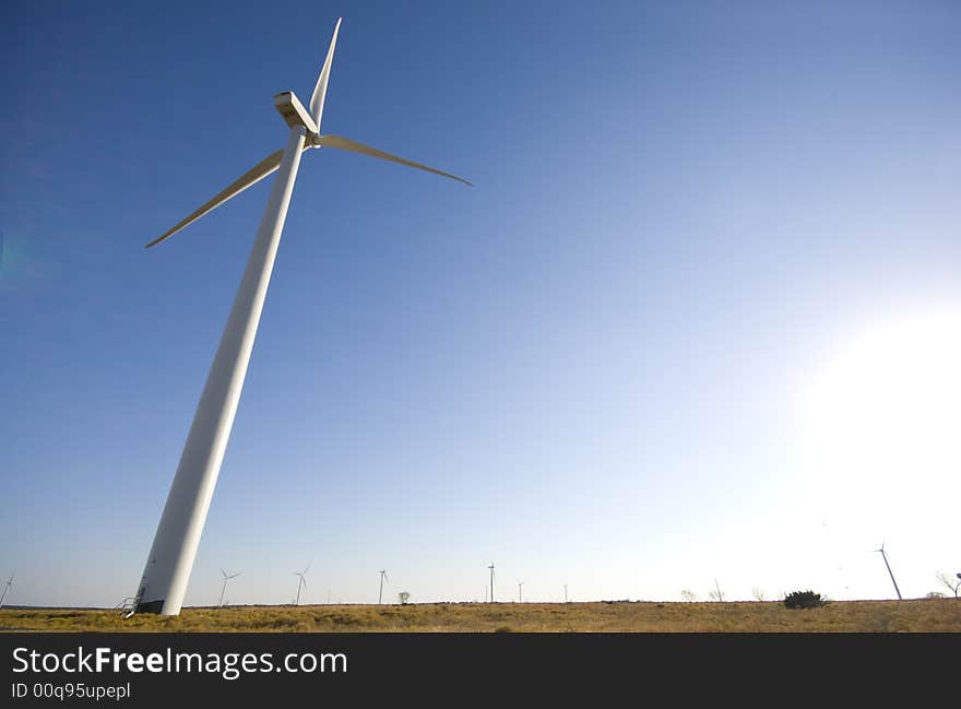 Energy producing wind turbines against a blue sky with copy space