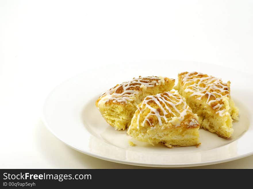 Fresh, moist pieces of streusel cheese coffee cake on white plate with white background. Fresh, moist pieces of streusel cheese coffee cake on white plate with white background.