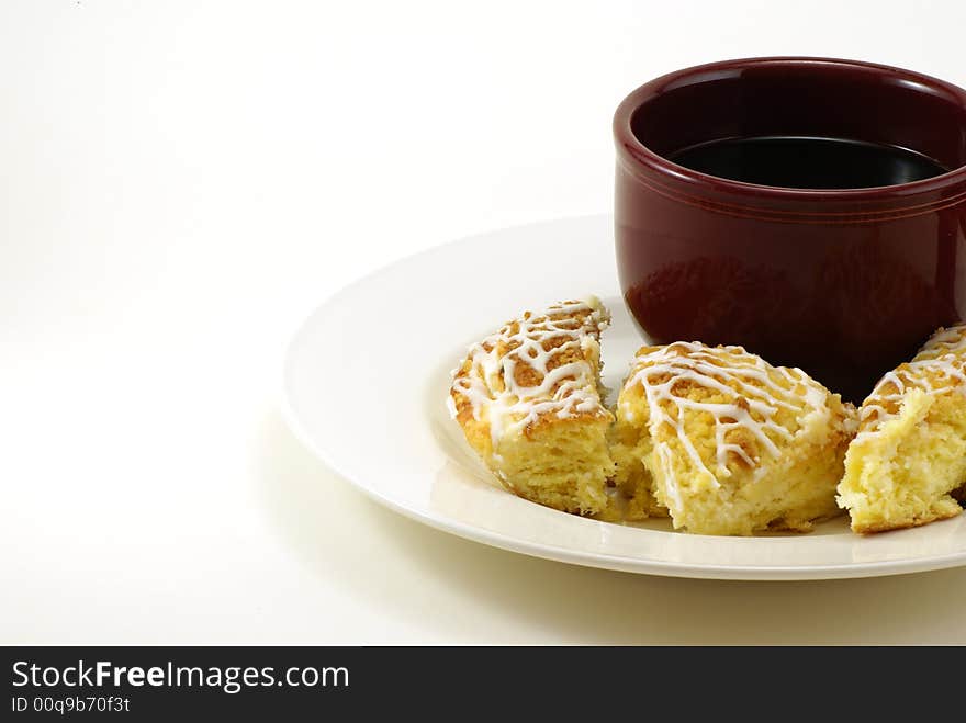 Large mug of coffee with pieces of streusel coffee cheese crumb cake on white plate with white background. Large mug of coffee with pieces of streusel coffee cheese crumb cake on white plate with white background.