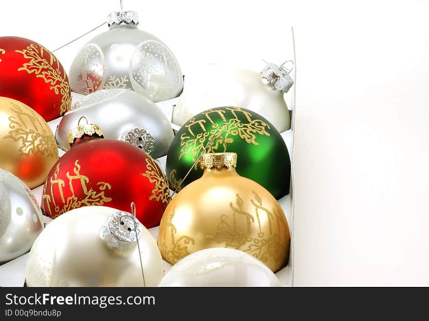 Shiny Christmas ornaments still in the box, waiting to be hung on the tree.