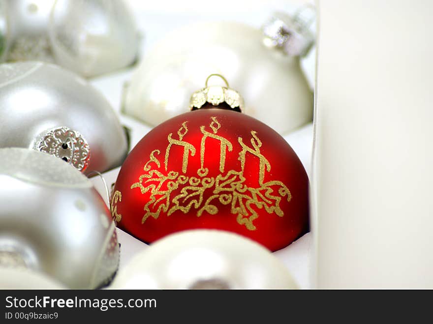 Shiny Red Christmas ornament still in the box, surounded by silver and white, waiting to be hung on the tree. Shiny Red Christmas ornament still in the box, surounded by silver and white, waiting to be hung on the tree.