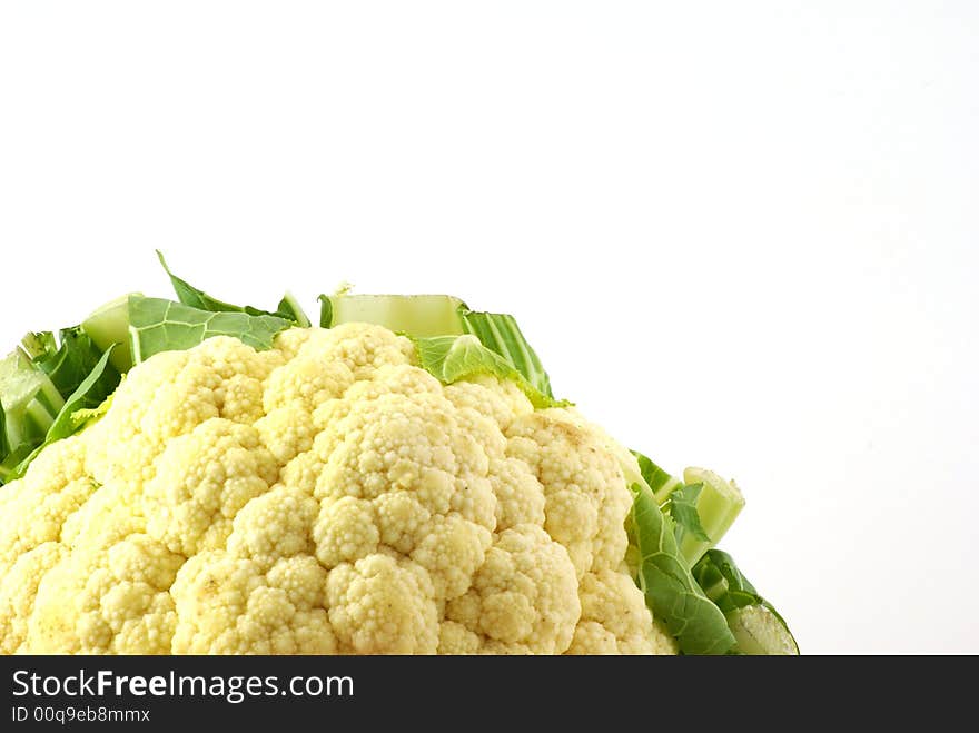 Close up of fresh raw cauliflower head surrounded by leaves.