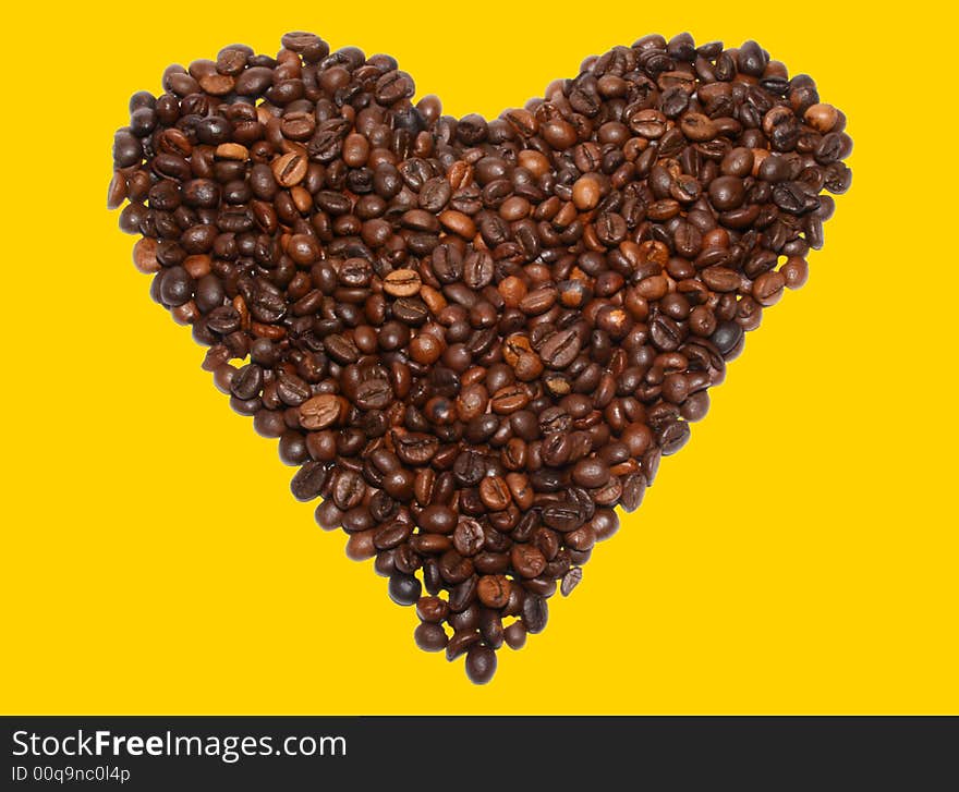 Beans of coffee in the form of heart on a yellow background