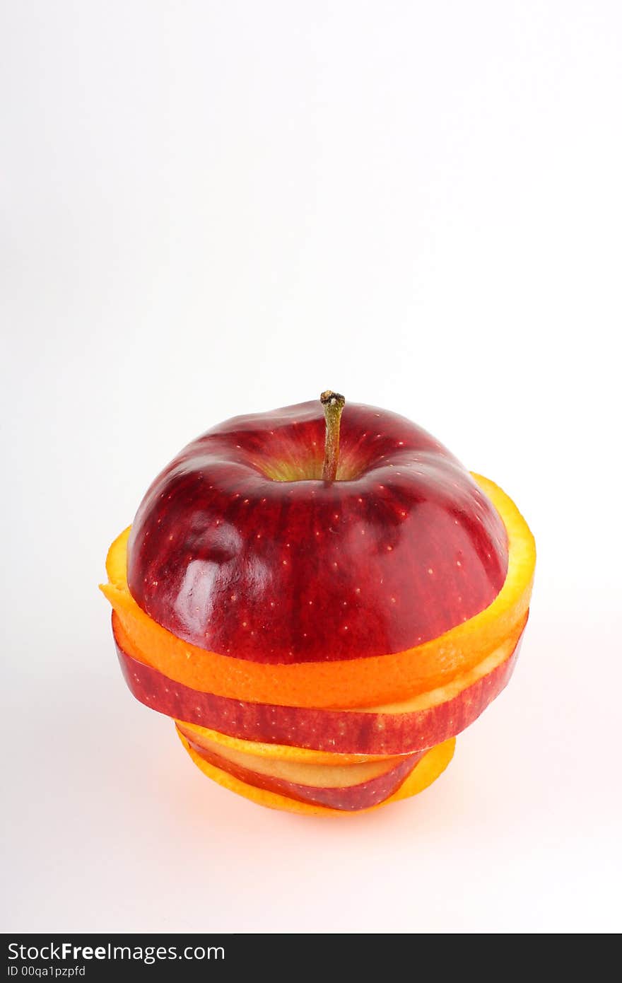 Slices of apple and orange put together to form one fruit shot on white in studio. Slices of apple and orange put together to form one fruit shot on white in studio