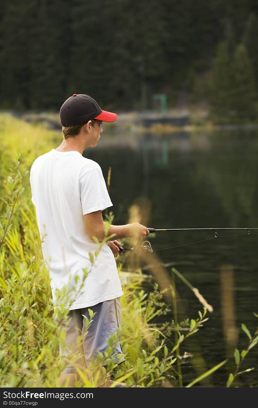 Boy out fishing at a small mountian lake. Boy out fishing at a small mountian lake