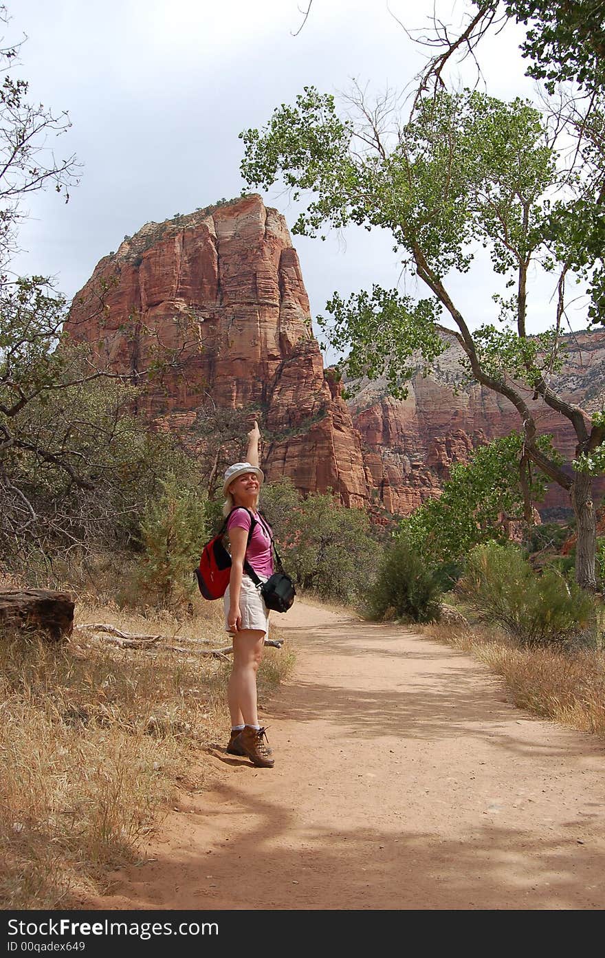 Young tourist woman showing Angel's Landing Point in the Zion National Park, USA