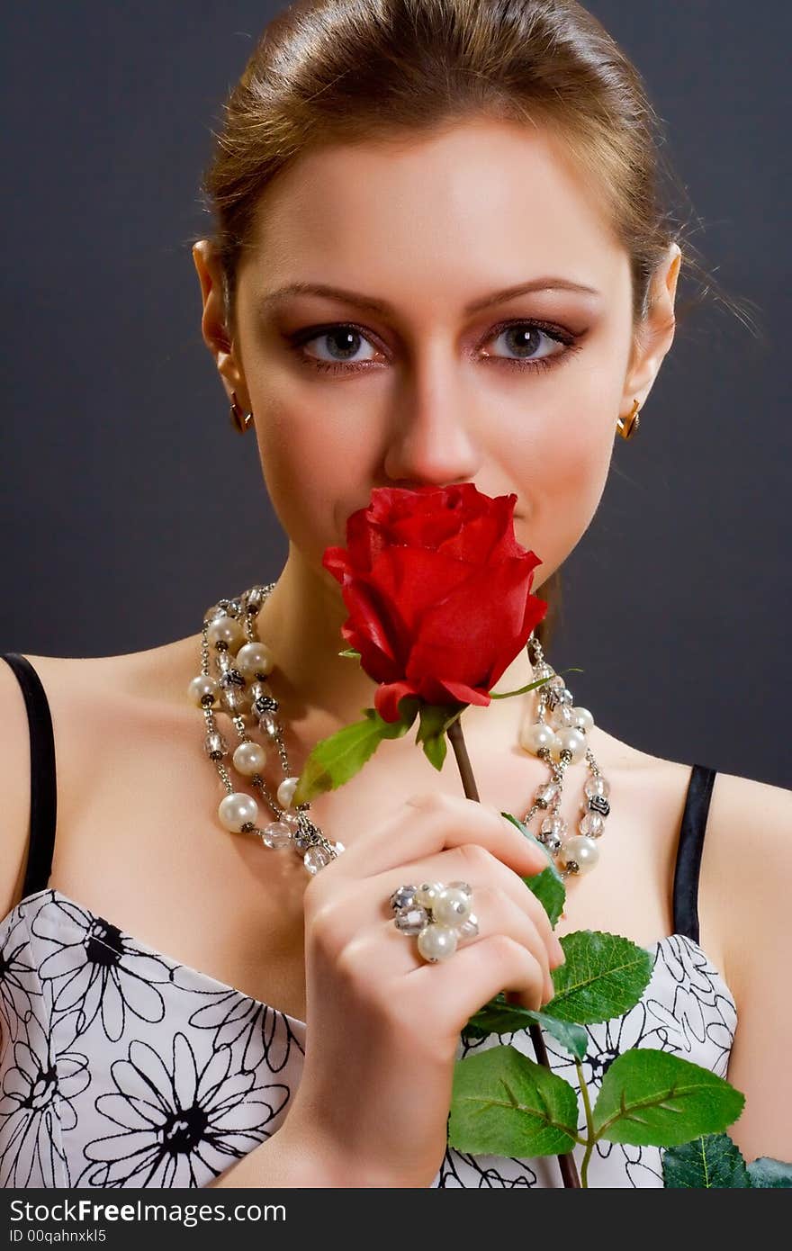 Woman with rose over dark background