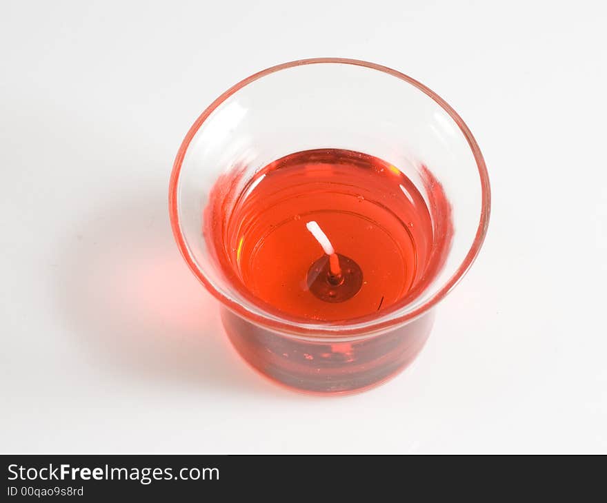 Top view of bright red candle in glass