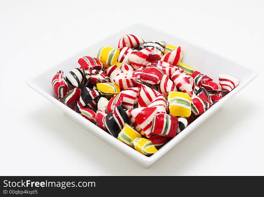 A bowl of hard candy shot on white, very colorful and saturated colors. A bowl of hard candy shot on white, very colorful and saturated colors