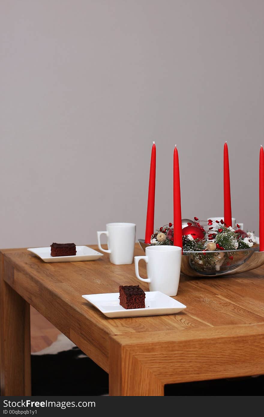 Table decorated with christmas decoration, set with cups of cocoa and chocolate cakes. Table decorated with christmas decoration, set with cups of cocoa and chocolate cakes