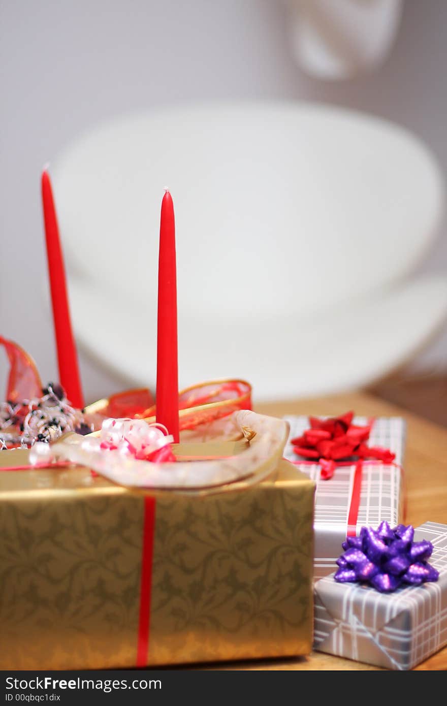 Christmas present on a table, ribbons and candle decorations around. Christmas present on a table, ribbons and candle decorations around