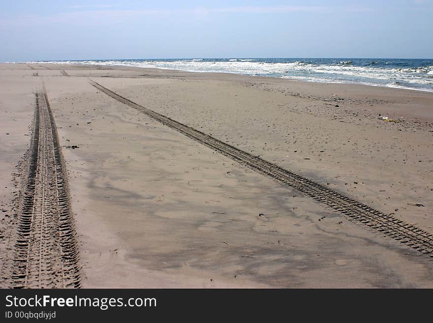 Wheel tracks on the empty beach sand