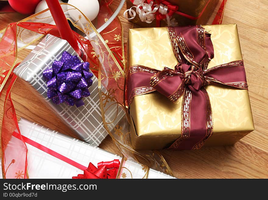 Christmas present on a solid oak table, ribbons and decorations around. Christmas present on a solid oak table, ribbons and decorations around