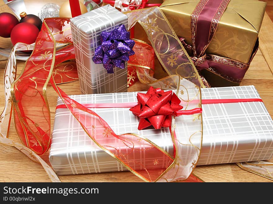 Christmas present on a solid oak table, ribbons and decorations around. Christmas present on a solid oak table, ribbons and decorations around