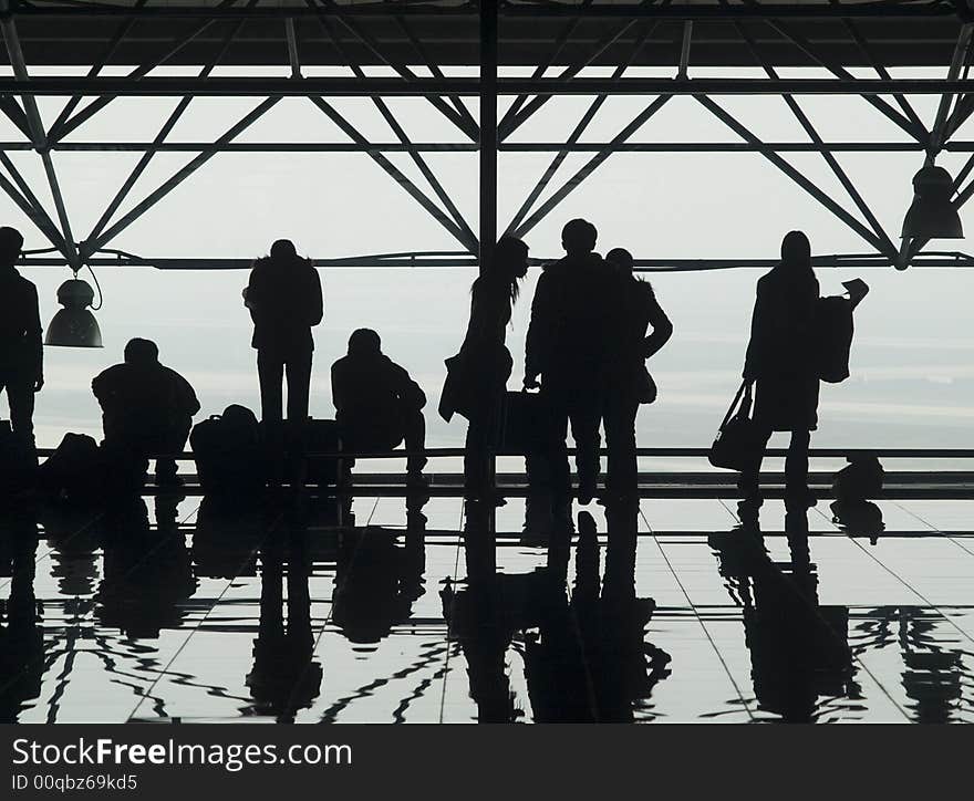 Silhouettes and reflections of passenger waiting at an airport. Silhouettes and reflections of passenger waiting at an airport