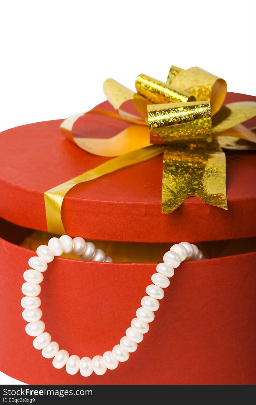 Closeup isolated heart shape box with pearl necklace and gold ribbon. Closeup isolated heart shape box with pearl necklace and gold ribbon