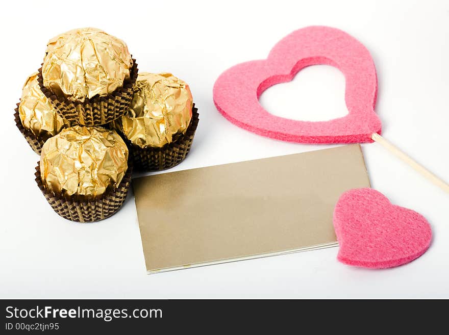 Candies and card and heart shapes on the white background. Candies and card and heart shapes on the white background