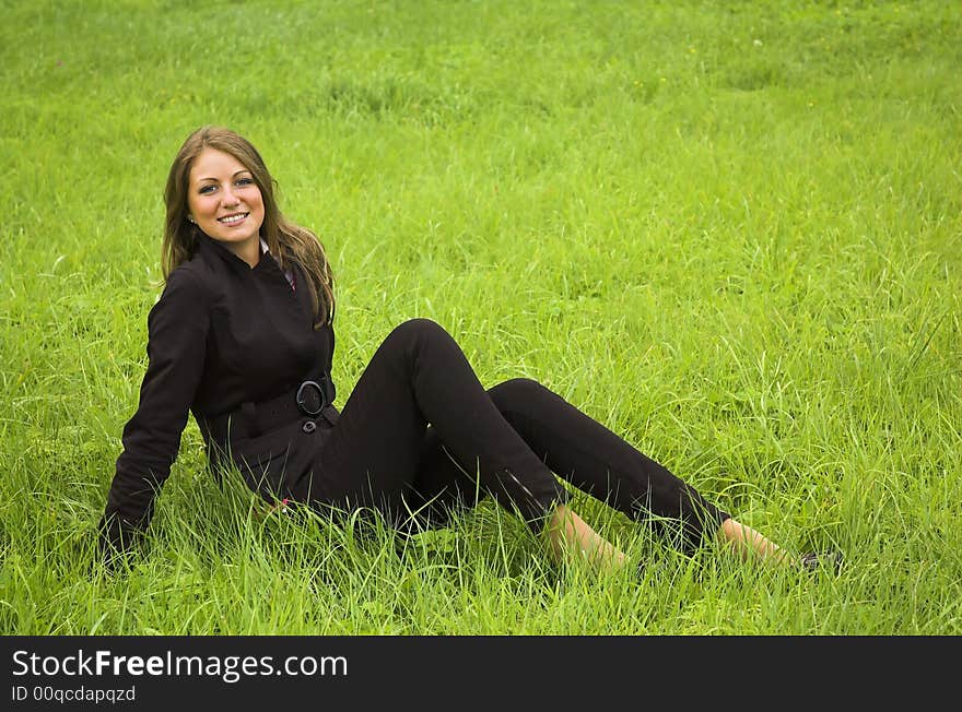 Girl Sits On A Green Grass