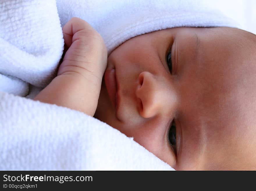 Week old baby boy on a blue blanket early in the morning. Week old baby boy on a blue blanket early in the morning