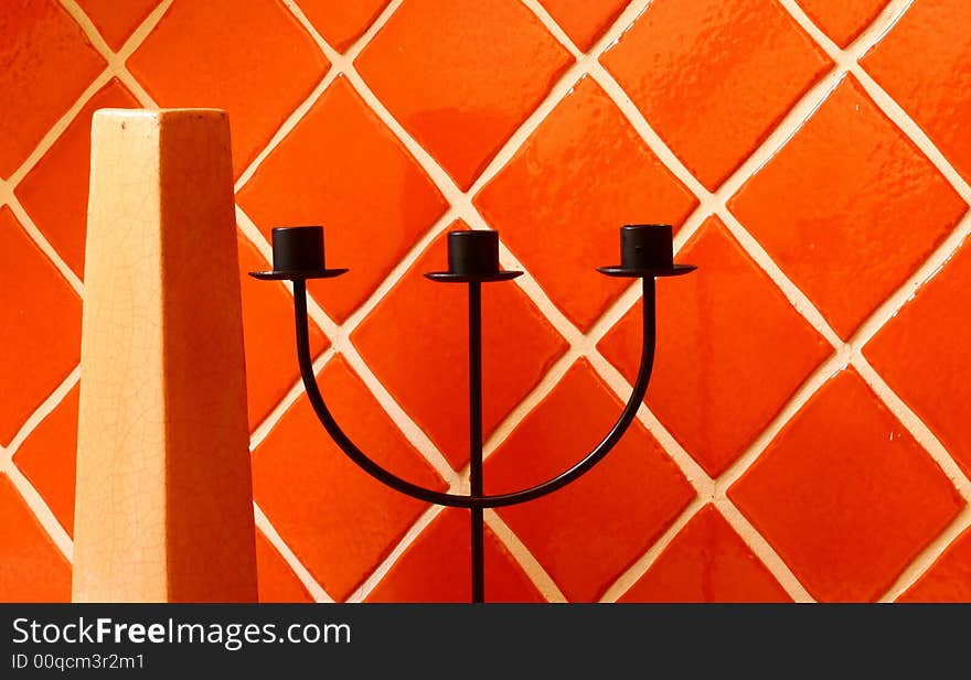 Vase and candle stick on ceramic wall