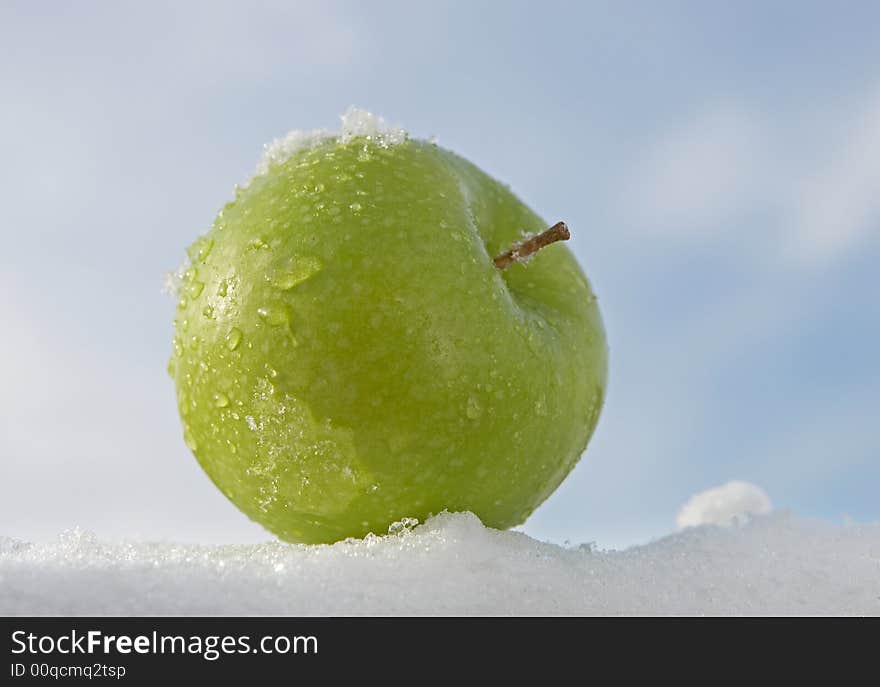 Fresh green apple on snow