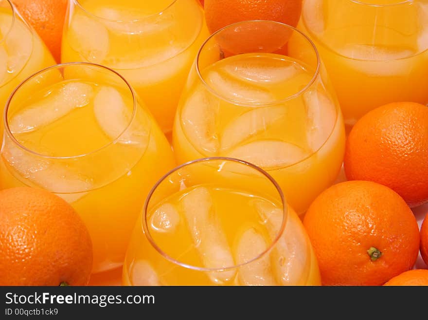 Glasses of freshly squeezed orange juice and oranges.