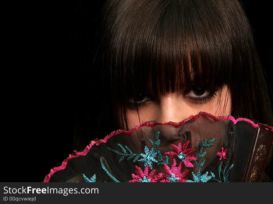 Girl with a spanish fan, on black background