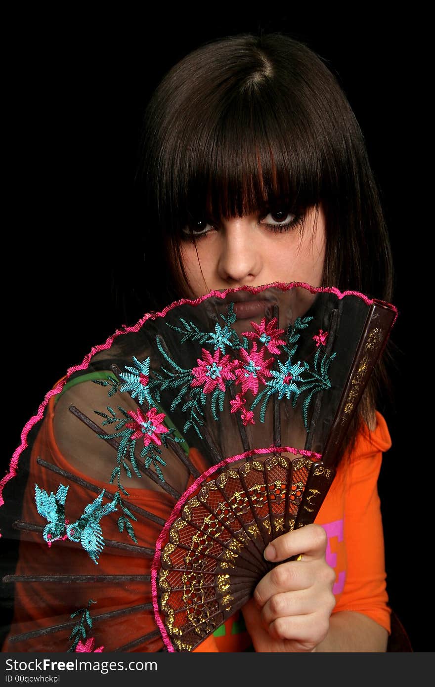 Girl with a spanish fan, on black background