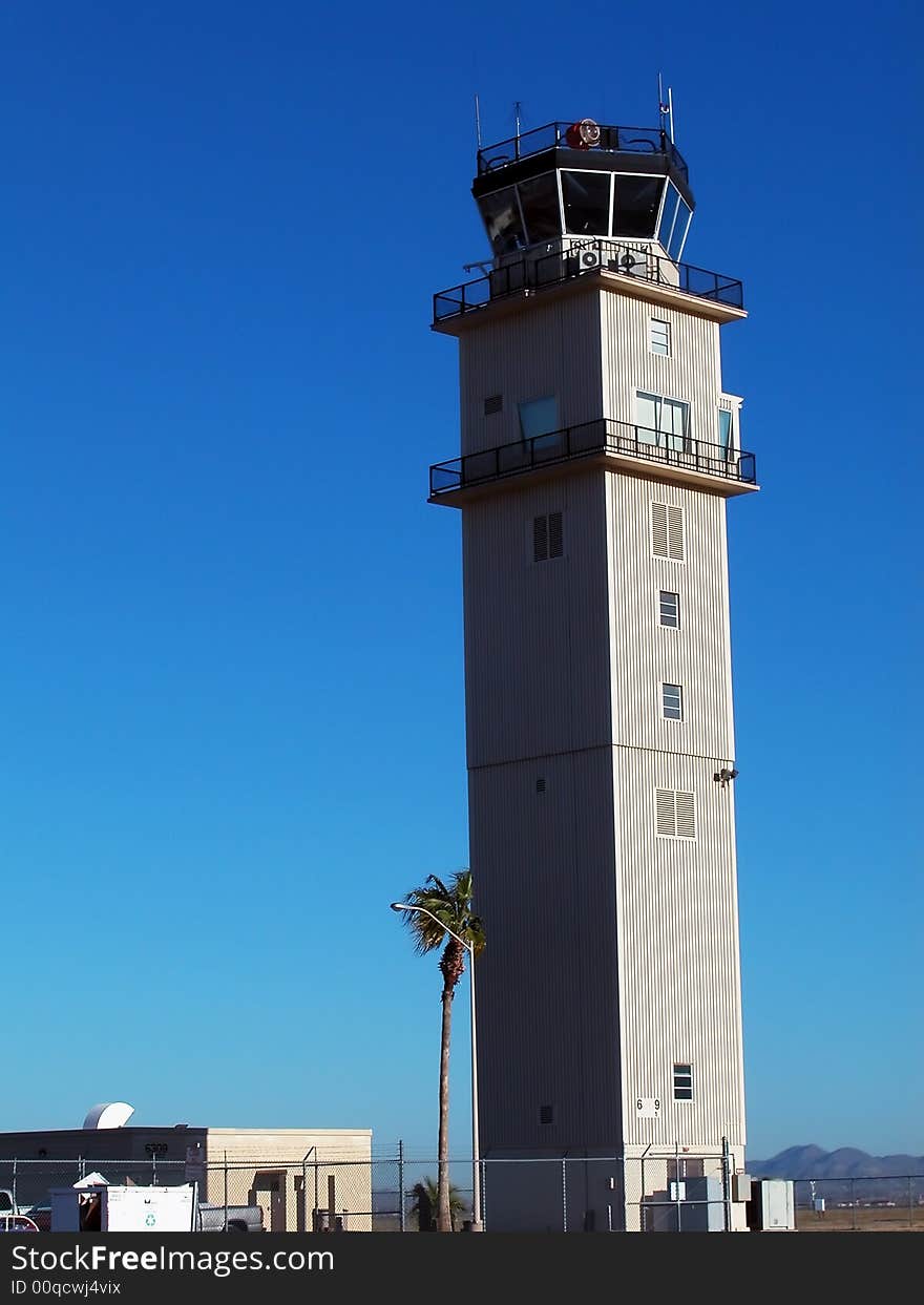 An airport control tower shot against a stunning, clear blue sky. An airport control tower shot against a stunning, clear blue sky