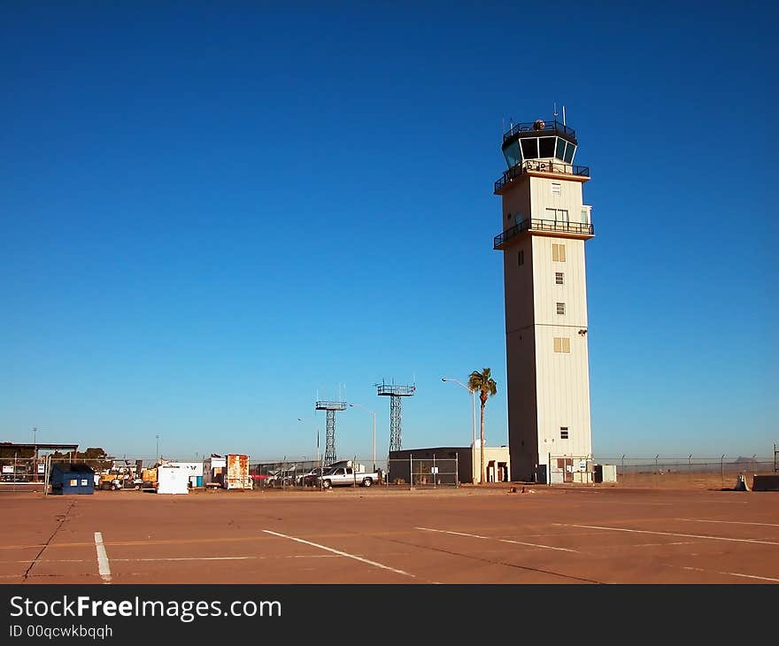 An airport control tower and tarmac shot against a stunning, clear blue sky. An airport control tower and tarmac shot against a stunning, clear blue sky