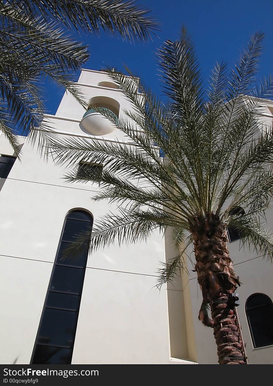 Tower of a religious hospital with cross on top shot against a deep blue sky. Tower of a religious hospital with cross on top shot against a deep blue sky