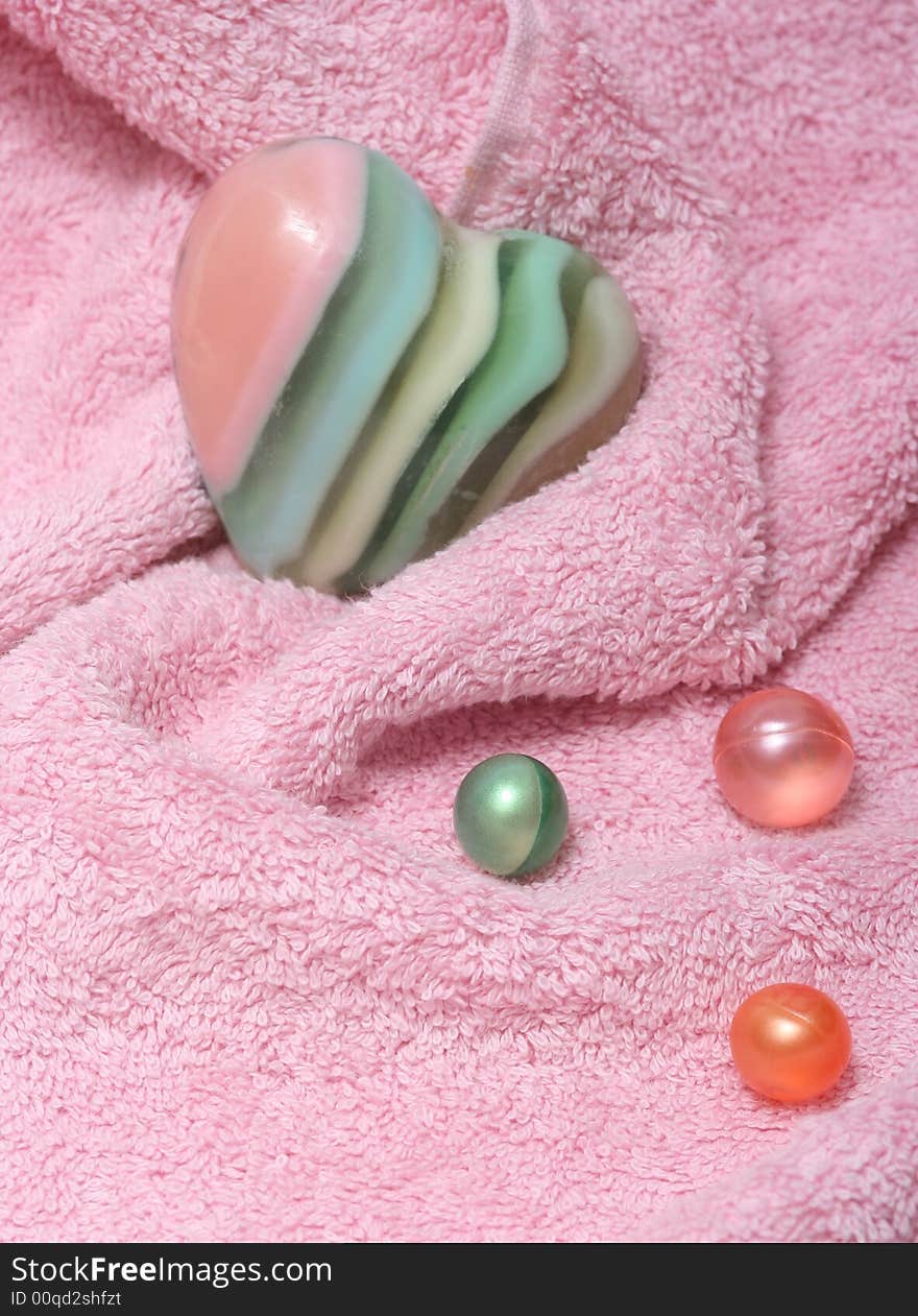 Pink towel,bath oil pearls and soap-heart. Pink towel,bath oil pearls and soap-heart